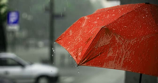 Un paraguas rojo en una escena callejera lluviosa