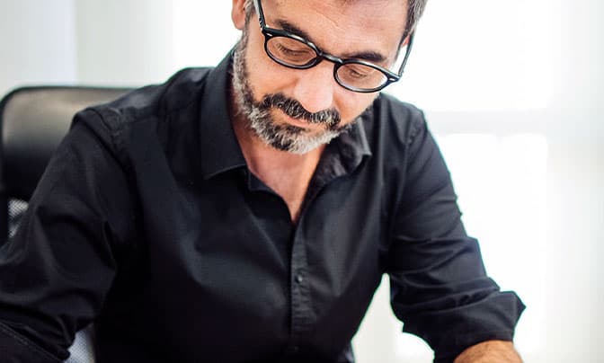 Toma frontal de Carlos Recio en su silla de escritorio